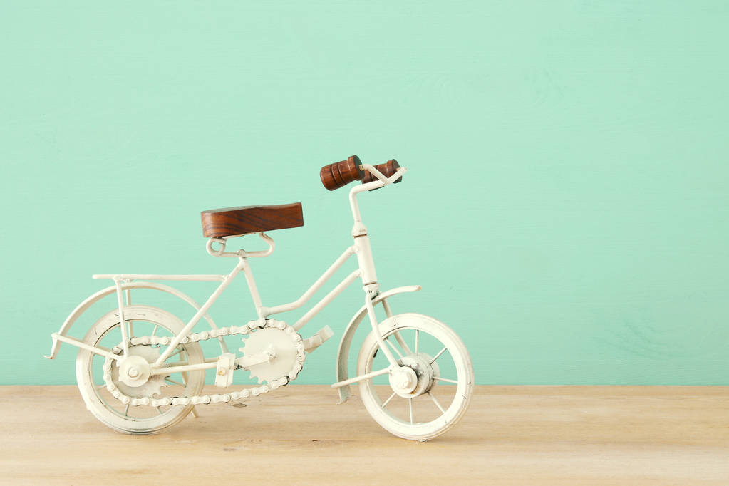 Brinquedo de bicicleta branca de metal vintage sobre mesa de madeira
. - Foto, Imagem