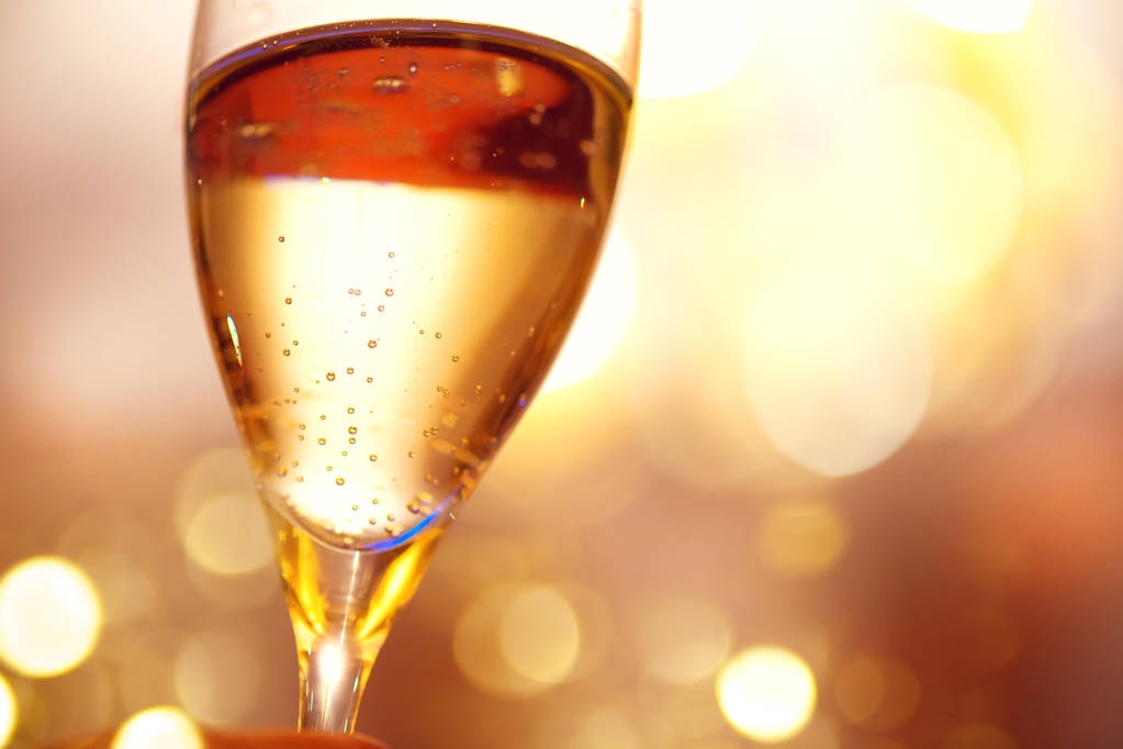 Glas met champagne over vakantie knipperende achtergrond - Foto, afbeelding
