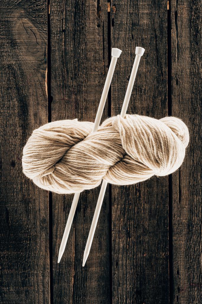 vista superior de lã branca com agulhas de tricô no fundo de madeira
 - Foto, Imagem