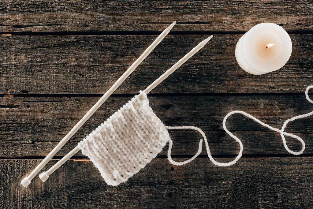 vue de dessus des aiguilles à tricoter avec fil et bougie sur fond en bois
 - Photo, image