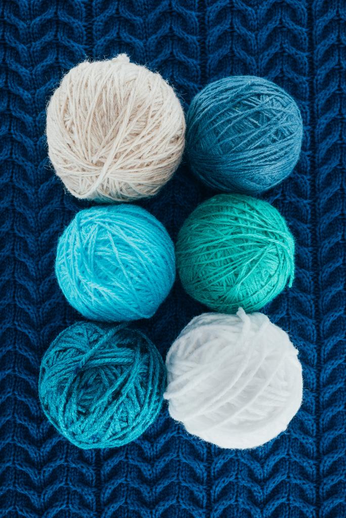 top view of different knitting yarn balls on blue knit - Photo, Image