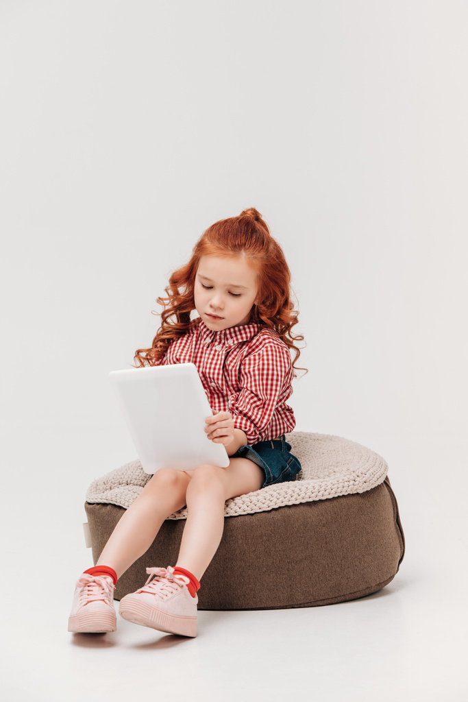 sevimli küçük çocuk oturma ve dijital tablet gri izole kullanma - Fotoğraf, Görsel
