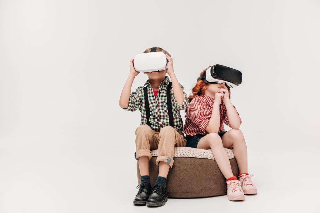 aranyos kis gyermekek, ül és szürke elszigetelt virtuális valóság fejhallgatók használata - Fotó, kép