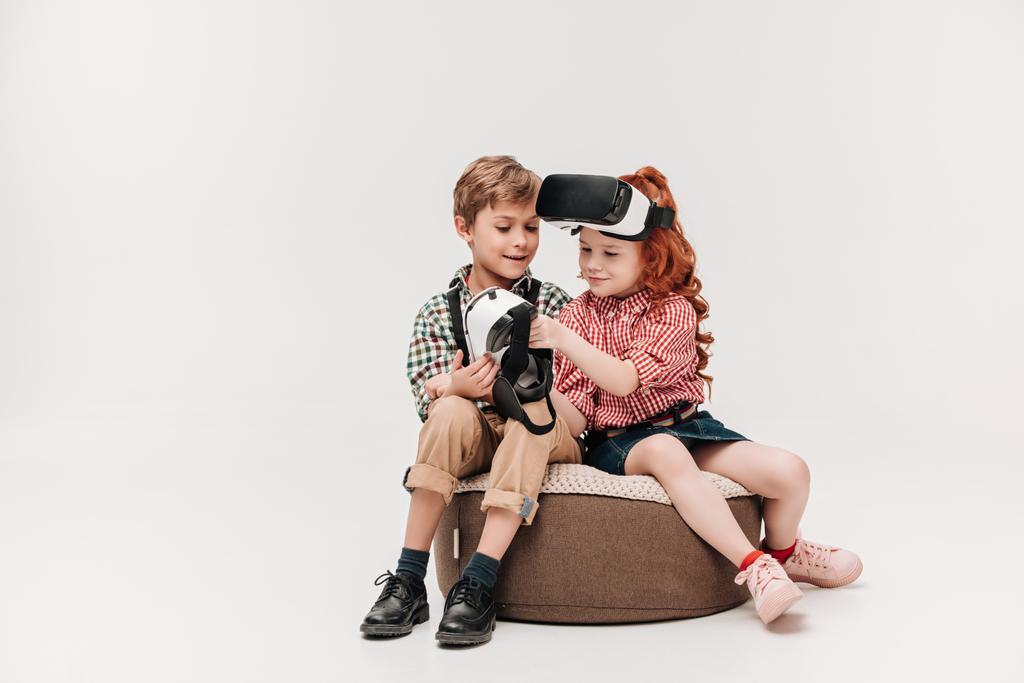 красивые маленькие дети, использующие гарнитуры виртуальной реальности, изолированные на сером
 - Фото, изображение
