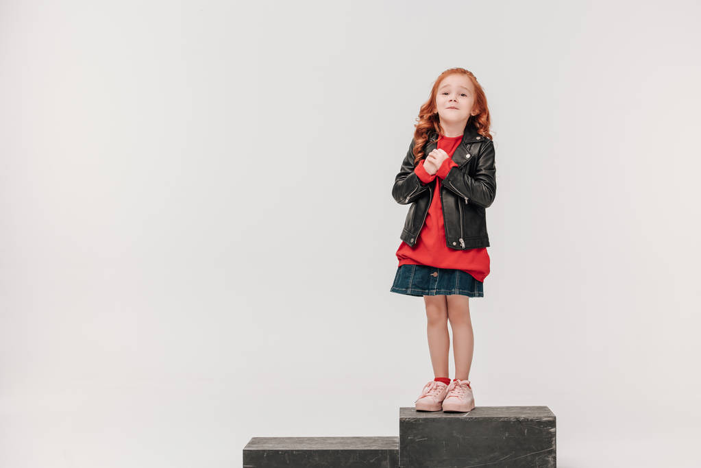 adorable little girl in leather jacket on wooden box isolated on grey - Photo, Image