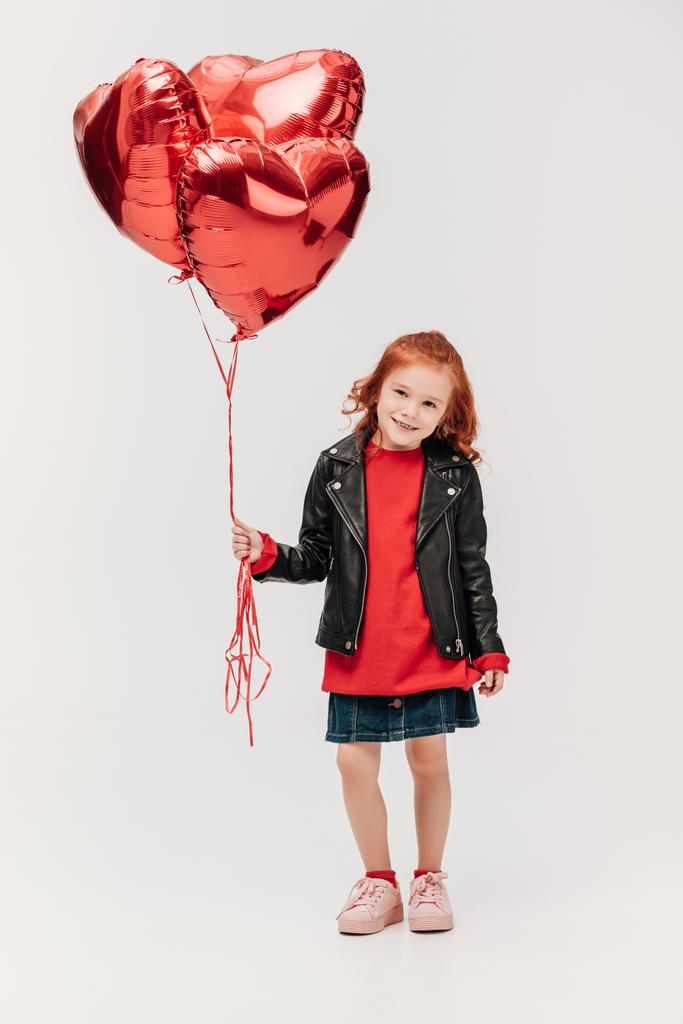 adorable little girl with balloons in shape of hearts isolated on grey - Photo, Image