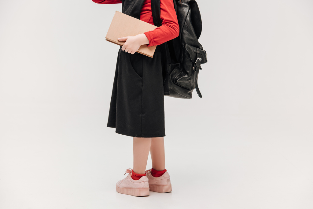 обрезанный снимок маленькой школьницы, изолированной на серой
 - Фото, изображение