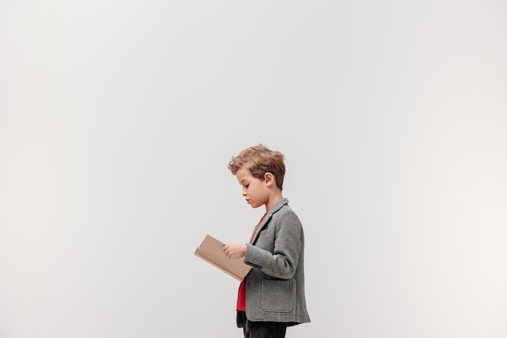 вид збоку стильна книжка для читання маленького школяра ізольована на сірому
 - Фото, зображення