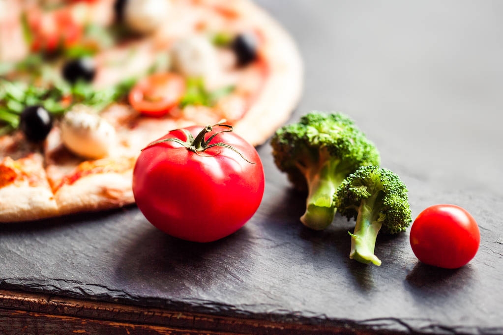 Pizza casera caliente de pepperoni lista para comer sobre fondo negro Ingredientes alimentarios y especias para cocinar
 - Foto, imagen