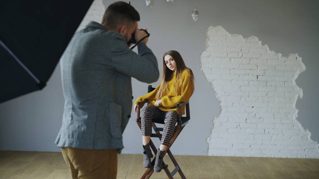 junge schöne Frau Modell posiert für Fotograf, während er mit einer Digitalkamera in Fotostudio drinnen schießt - Foto, Bild