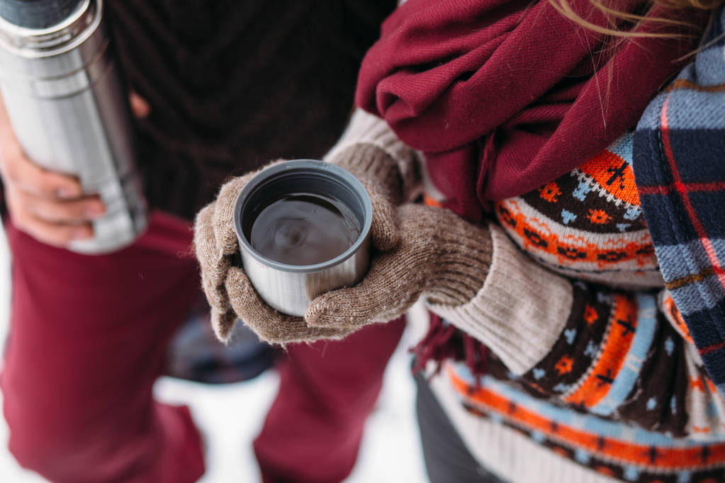 Une tasse de thé d'un thermos lors d'un pique-nique hivernal dans les bois
 - Photo, image