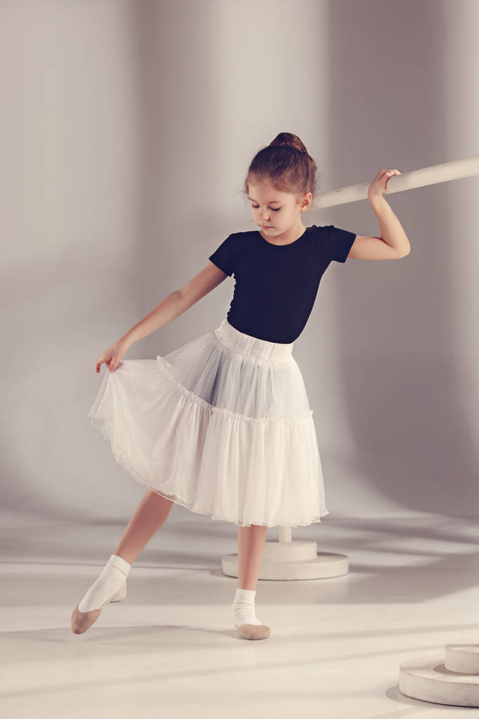 Маленькая балерина танцовщица на сером фоне
 - Фото, изображение