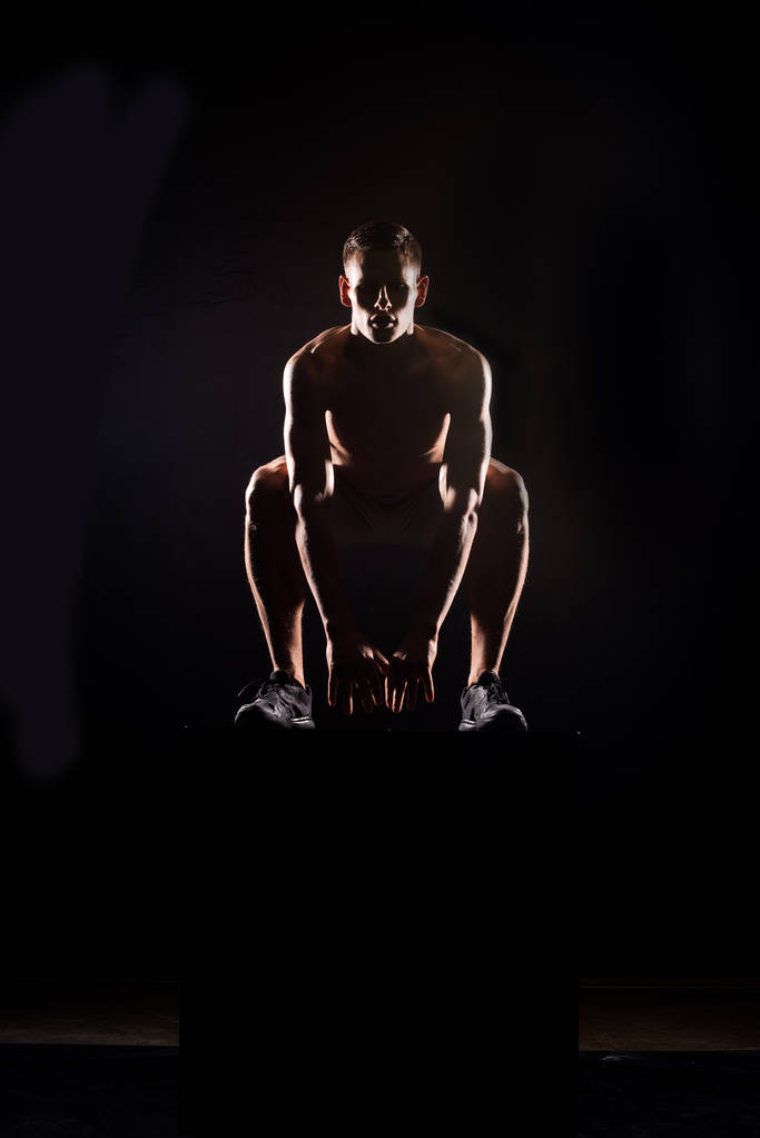 silhouette de jeune sportif athlétique sautant du bloc sur noir
 - Photo, image