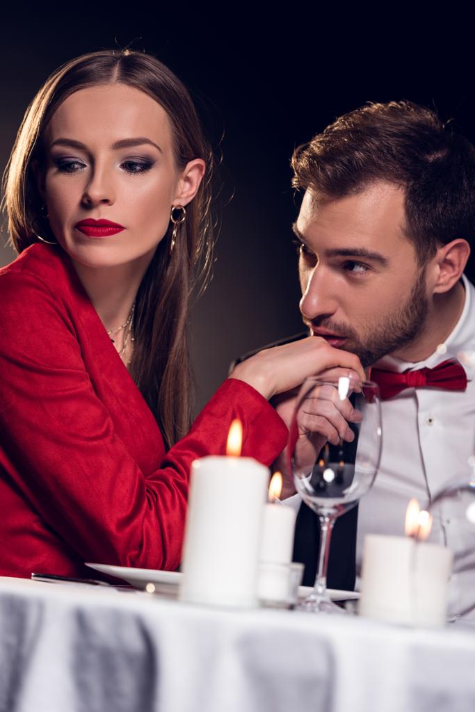 homem beijando mão de namorada chateada na data romântica no restaurante
 - Foto, Imagem