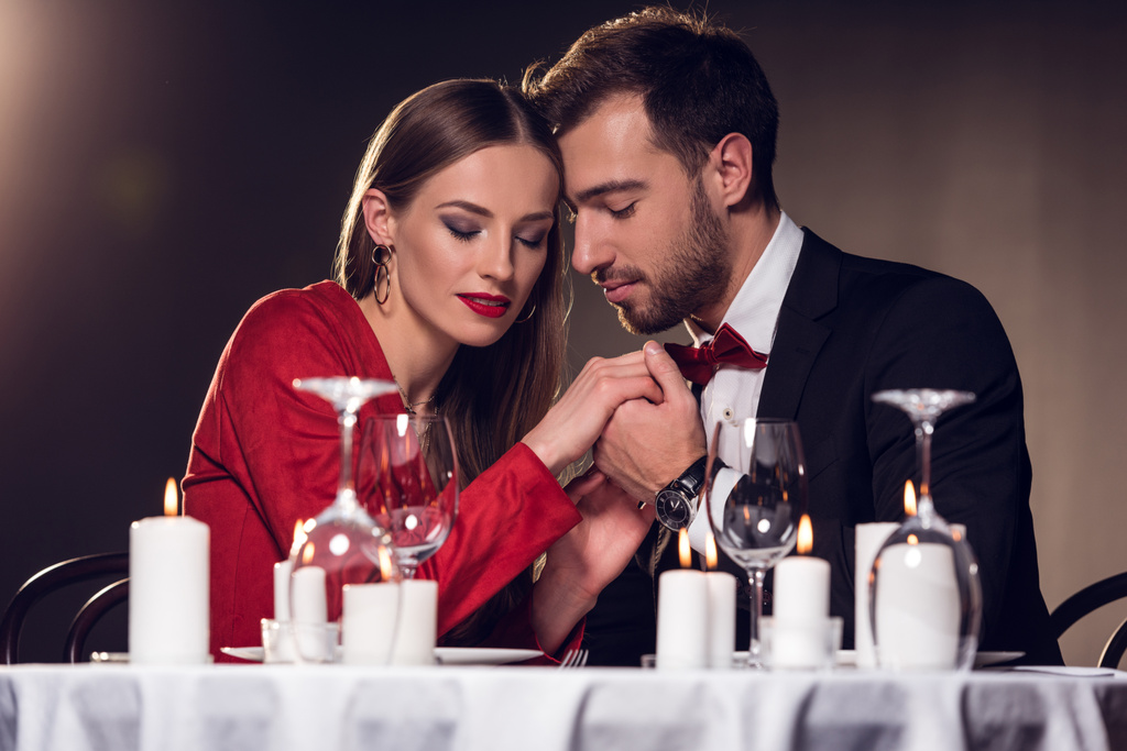 красивая нежная пара, держащаяся за руки в ресторане
 - Фото, изображение
