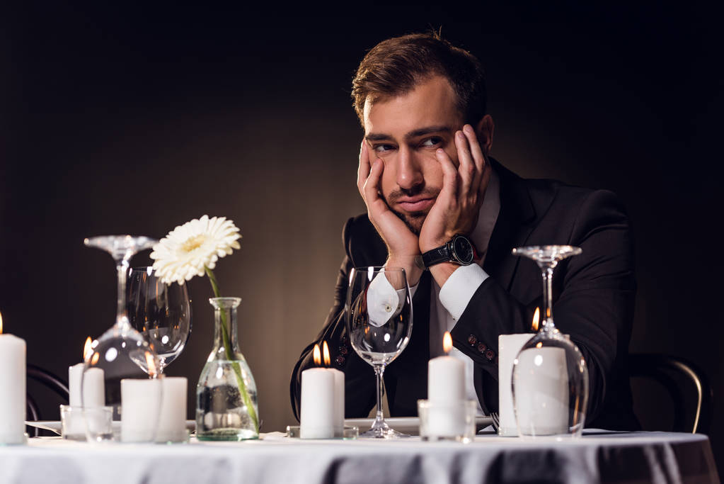 Verärgerter schöner Mann wartet auf romantisches Date im Restaurant  - Foto, Bild