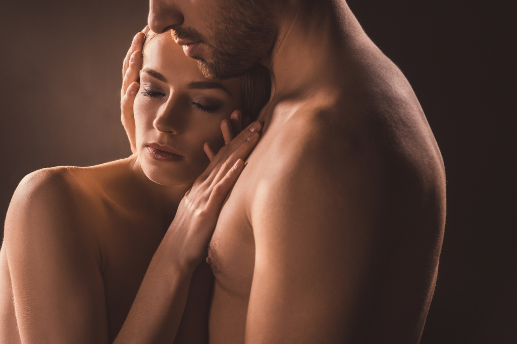 Γυμνή διαγωνισμού ζευγάρι αγκαλιάζει με κλειστά τα μάτια, σε καφέ  - Φωτογραφία, εικόνα