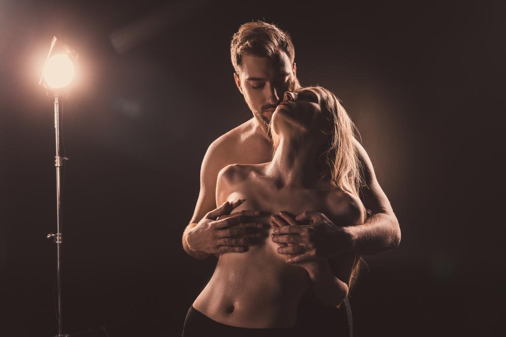 страстный парень трогает грудь своей сексуальной подружки, на коричневом
 - Фото, изображение