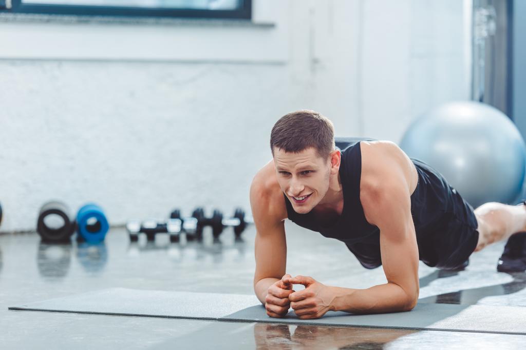 retrato de un joven deportista haciendo ejercicio en la esterilla en el gimnasio
 - Foto, Imagen