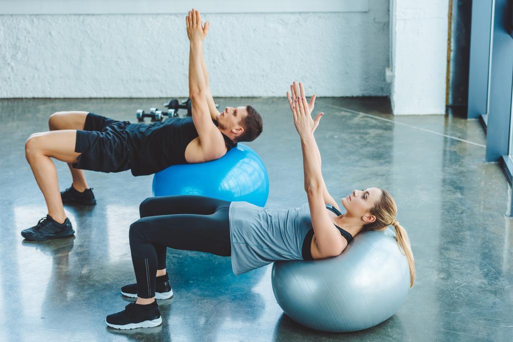 jeune homme et femme faisant de l'exercice sur des balles de fitness en salle de gym
 - Photo, image