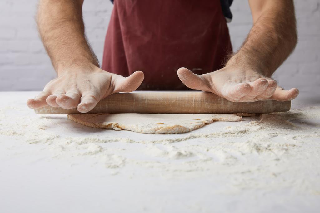 cropped image of chef rolling dough with rolling pin - Photo, Image