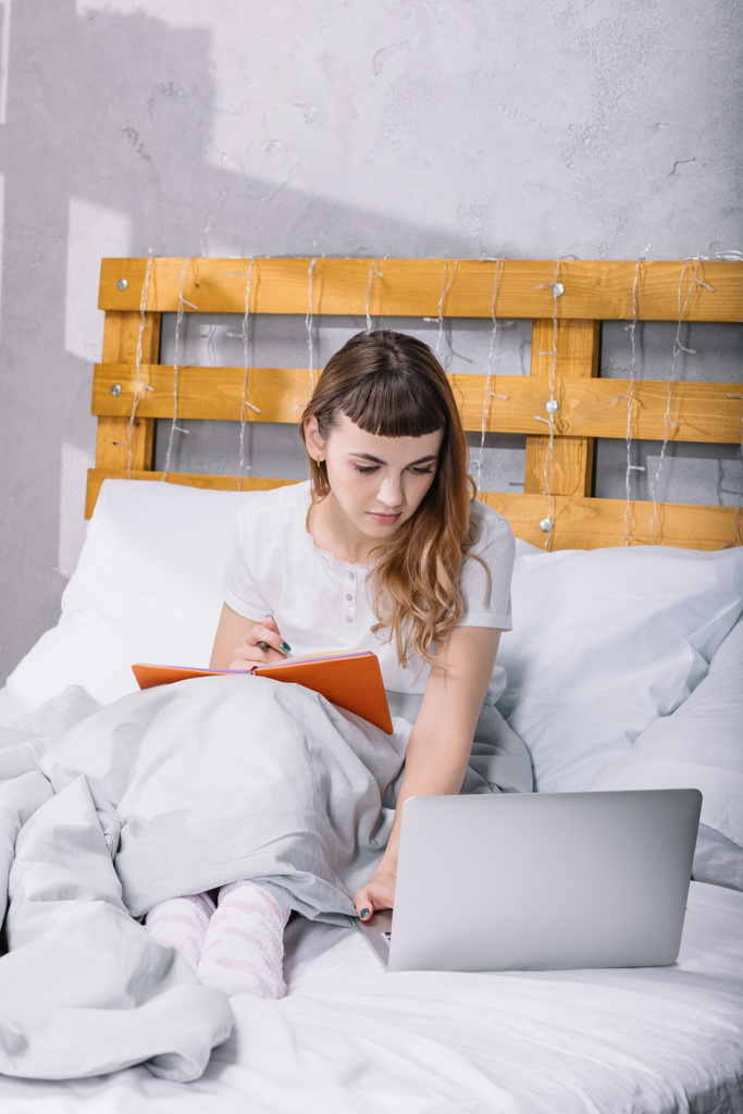 дівчина навчається в ліжку вранці і використовує ноутбук
 - Фото, зображення