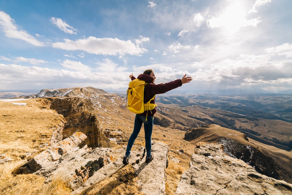 jeune fille active voyage à travers les montagnes du Caucase avec un sac à dos jaune, jouit de la nature
 - Photo, image