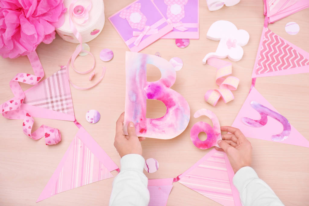 Woman preparing decorations for baby shower party on table - Photo, Image