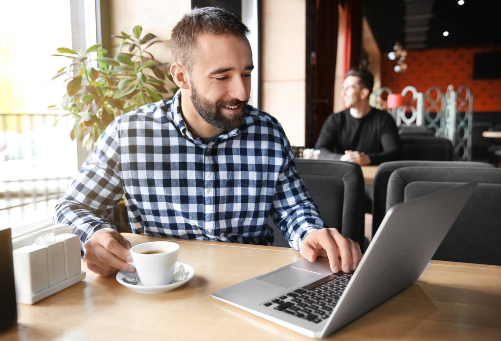 Giovane hipster uomo con caffè e laptop in caffè
 - Foto, immagini