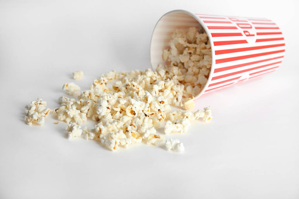 Papieren beker met lekkere popcorn op witte achtergrond - Foto, afbeelding