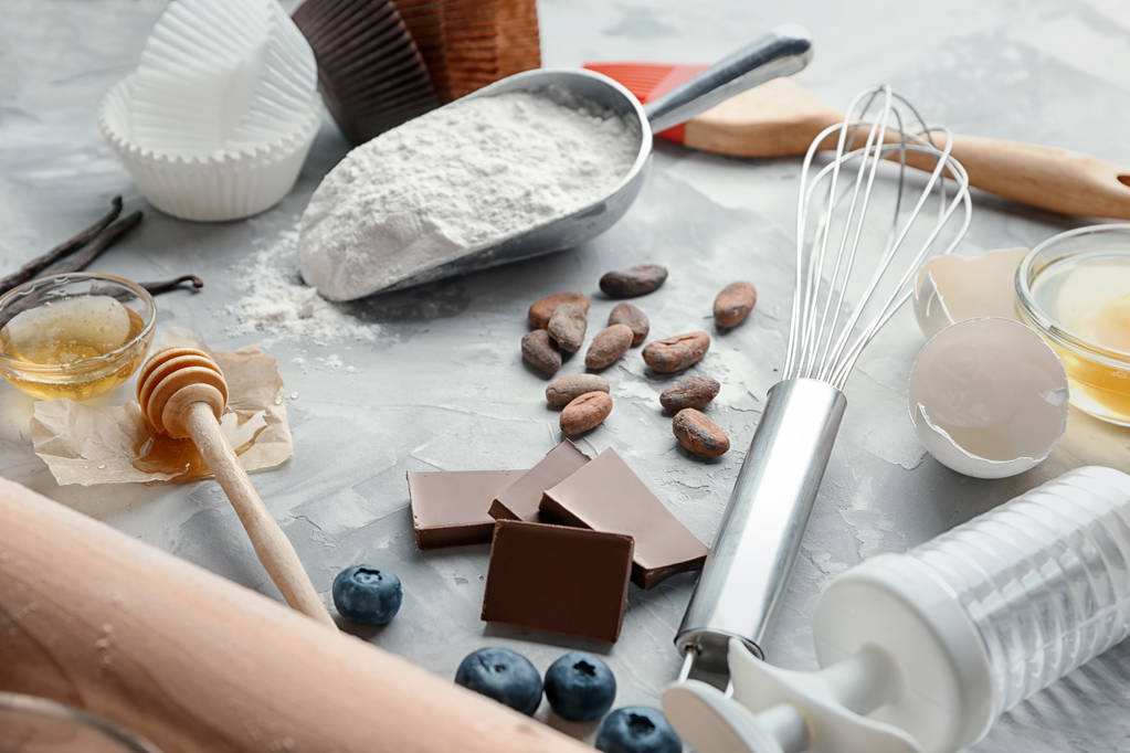 Ingredientes y utensilios para la cocción de pasteles sobre fondo gris
 - Foto, Imagen