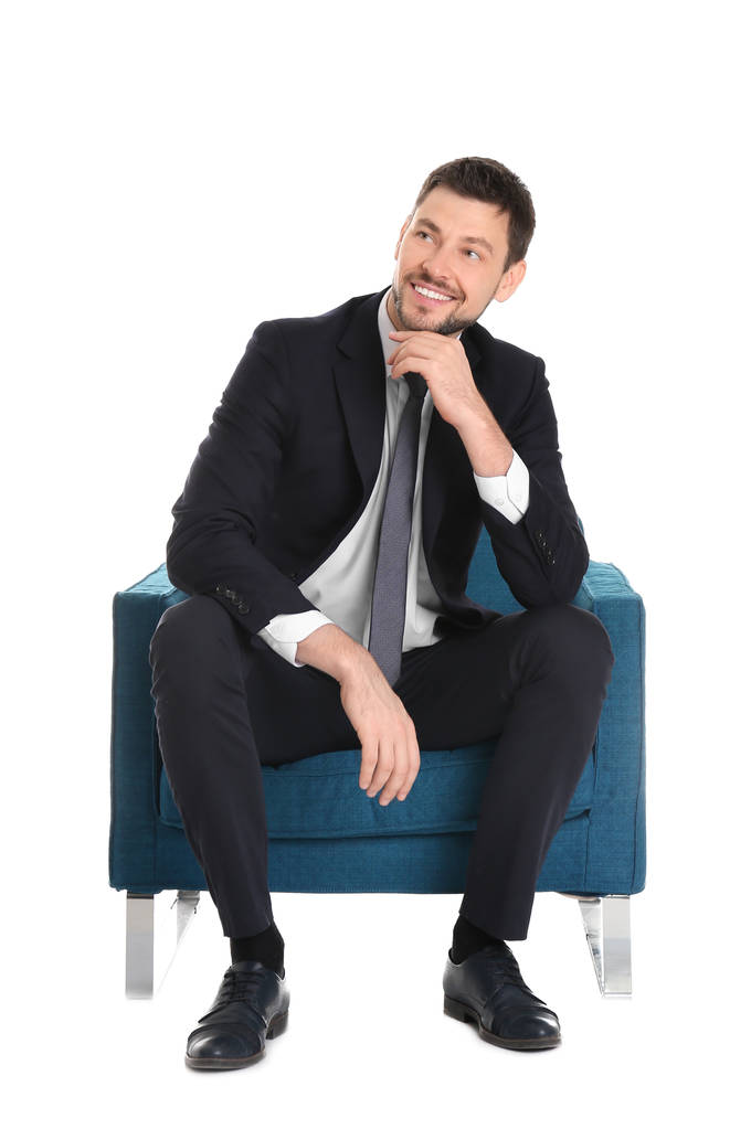 Hombre de negocios guapo sentado en cómodo sillón sobre fondo blanco
 - Foto, Imagen