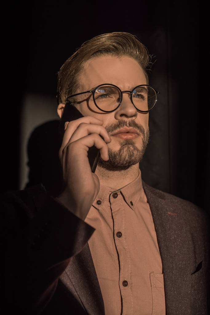 schöner, stylischer junger Mann mit Brille, der auf dem Smartphone spricht - Foto, Bild