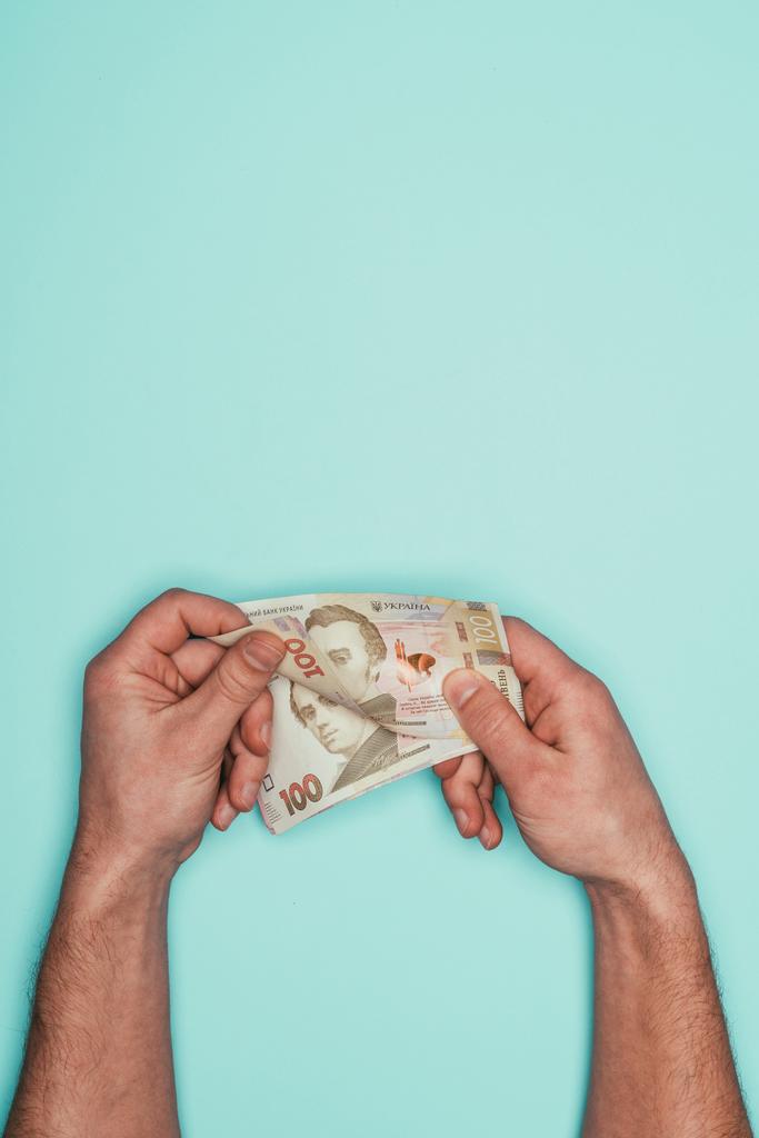 обрезанный снимок человека, подсчитывающего деньги, изолированные от бирюзы
 - Фото, изображение