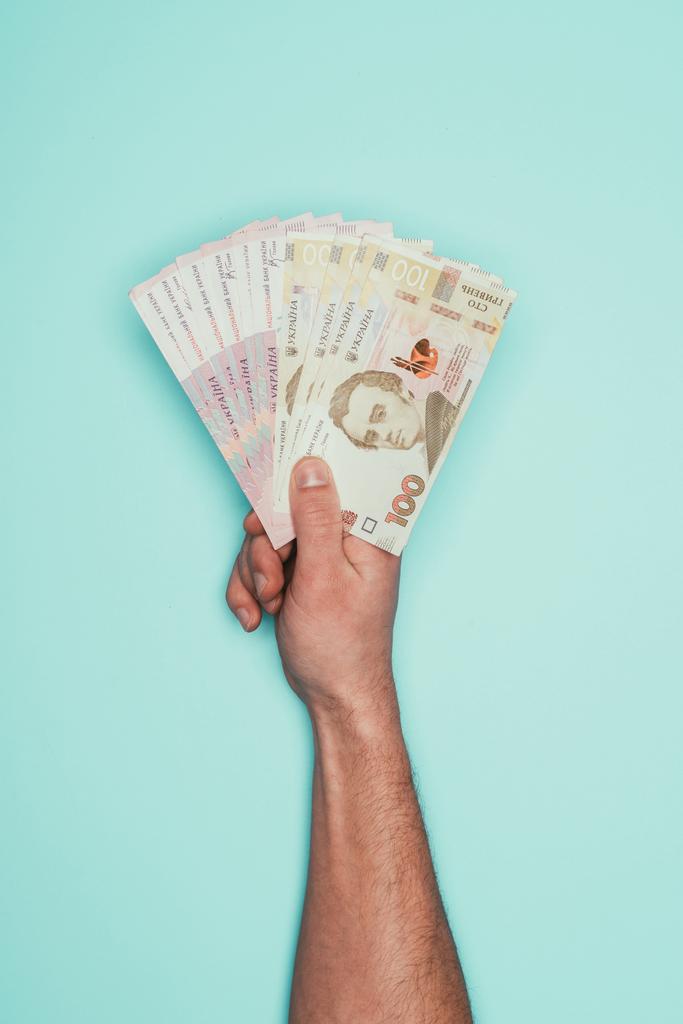 обрезанный снимок человека с украинскими деньгами, изолированными от бирюзы
 - Фото, изображение