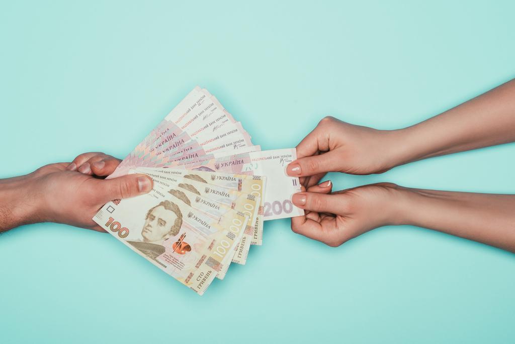 abgeschnittene Aufnahme von Frau, die Geld von Mann nimmt, isoliert auf Türkis - Foto, Bild