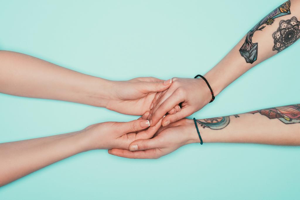 oříznuté záběr smyslné ženy držící rukou navzájem izolovaných na tyrkysové - Fotografie, Obrázek