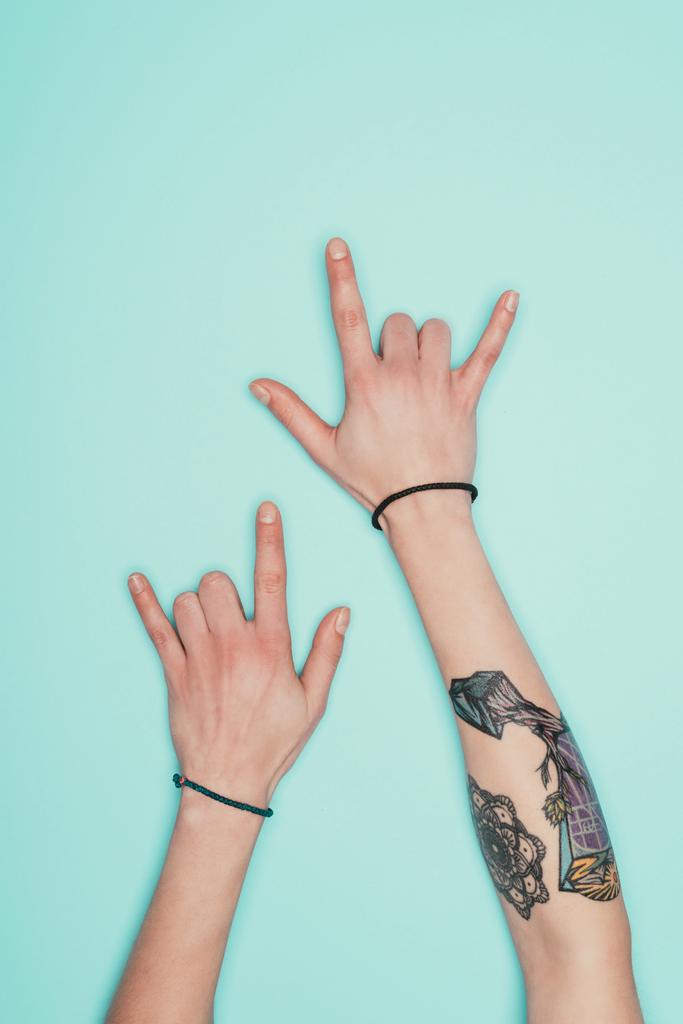 cropped shot of woman showing horns signs isolated on turquoise - Photo, Image