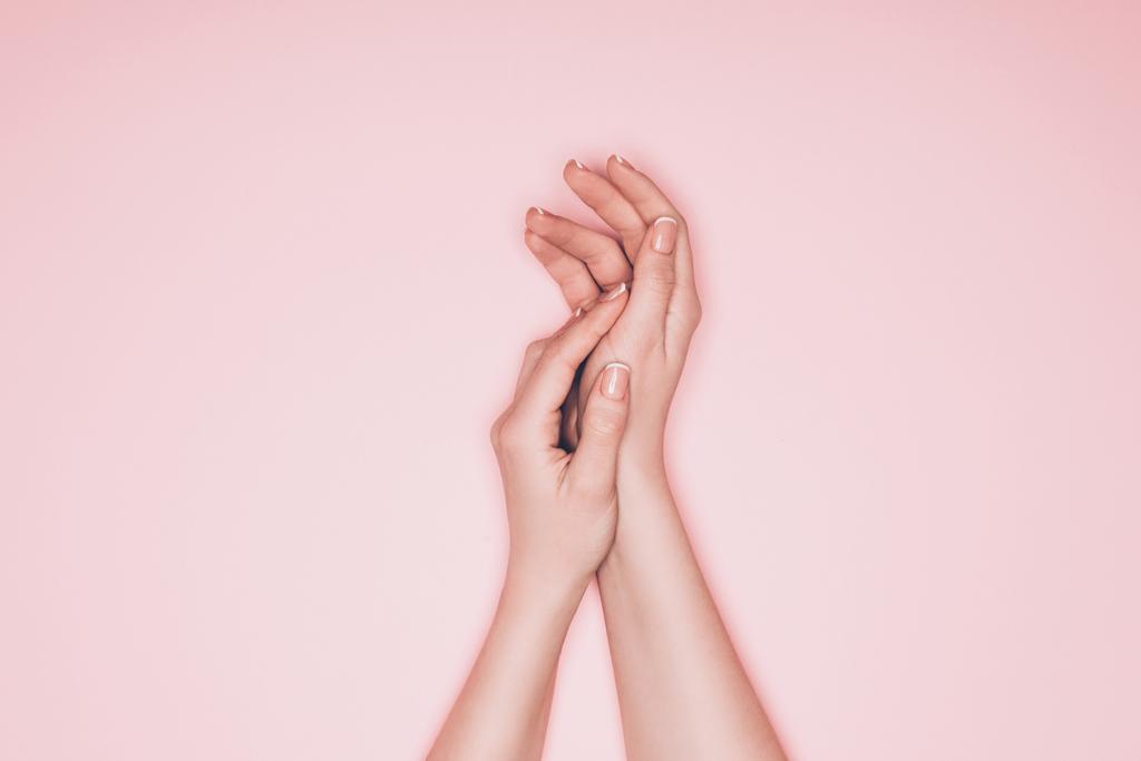 tiro recortado de las manos femeninas con la piel perfecta aislada en rosa
 - Foto, imagen