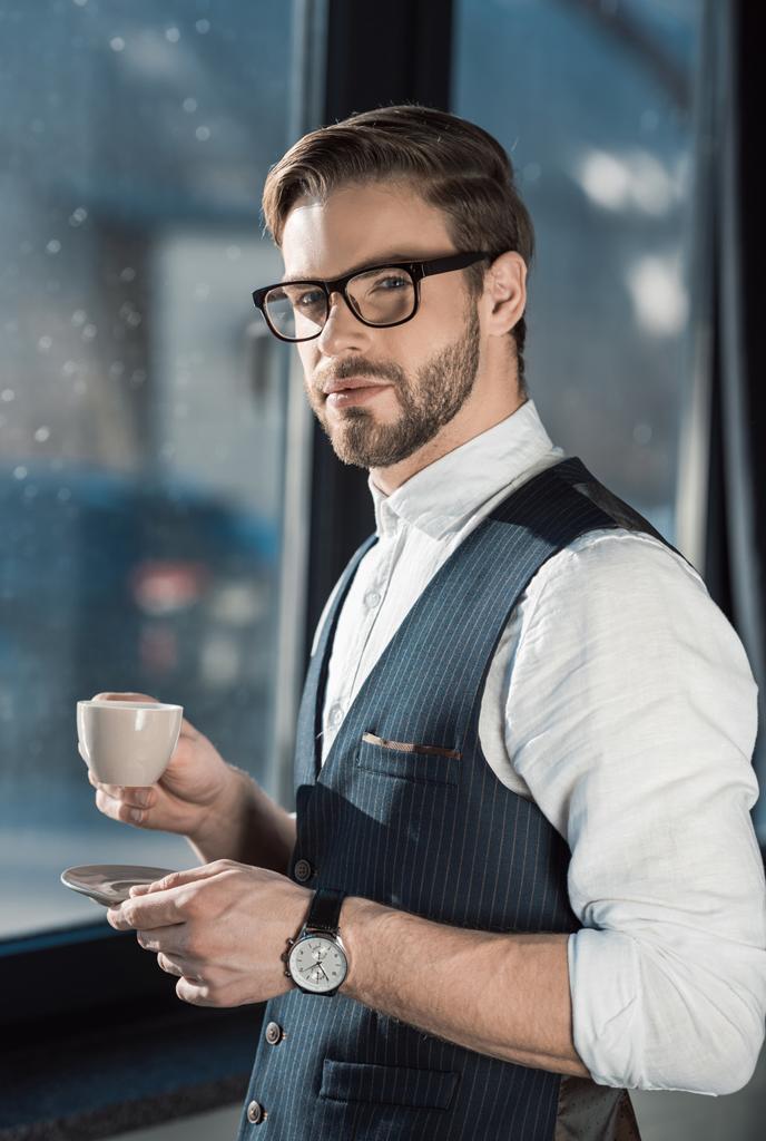 portret stylowy młody biznesmen w okularach picia kawy  - Zdjęcie, obraz