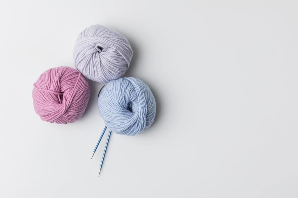 vue de dessus des boules de fil coloré et des aiguilles à tricoter isolées sur blanc
  - Photo, image