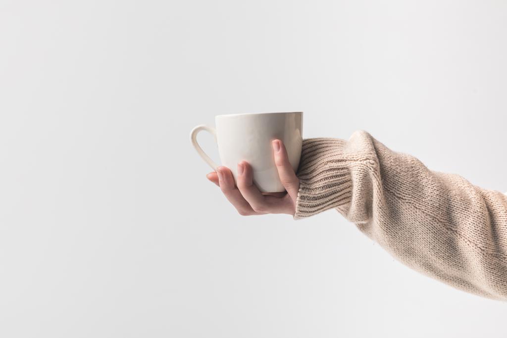 手にコーヒー カップを保持している女性のトリミングされた画像は、白で隔離 - 写真・画像