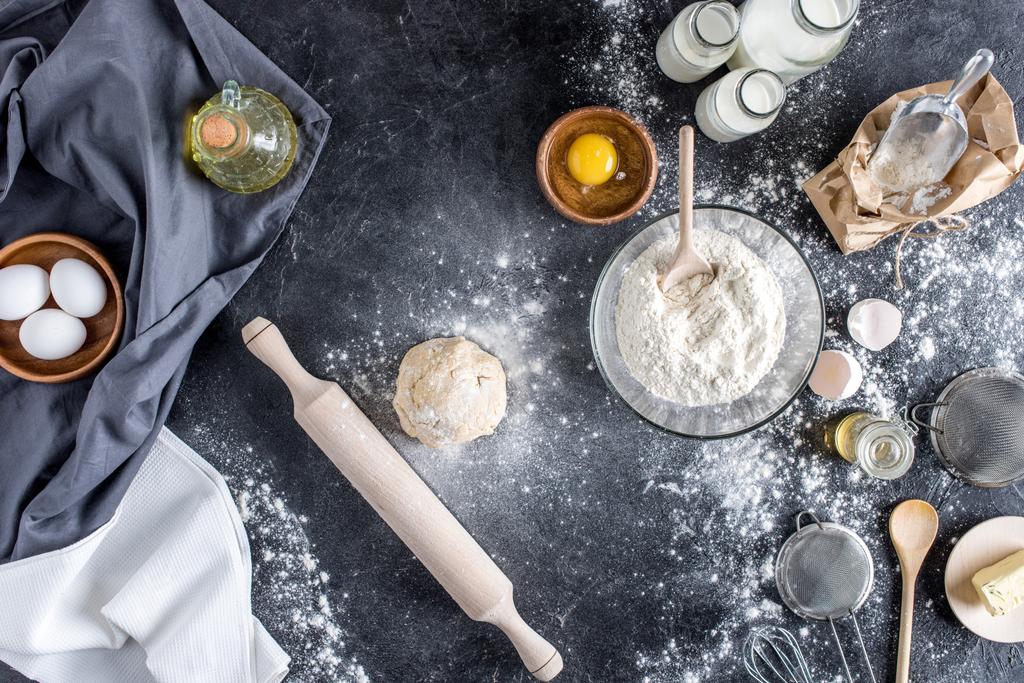 a nyers tészta, sütés, összetevők és evőeszközök márvány felületre felülnézet - Fotó, kép