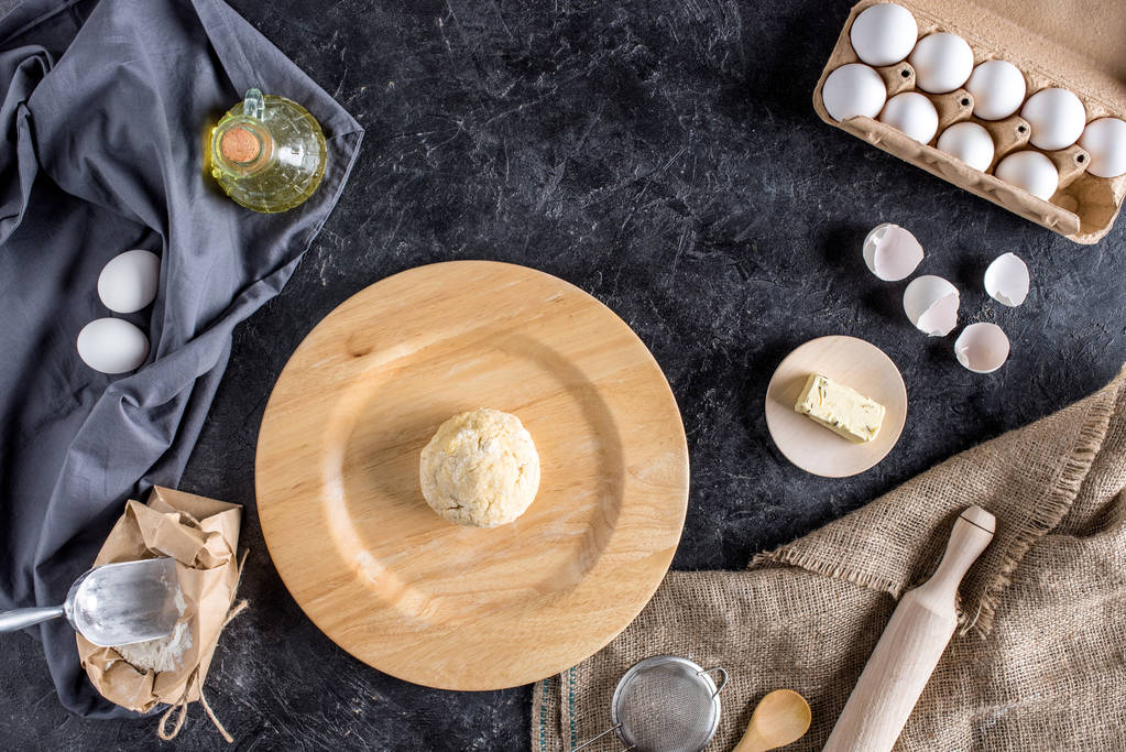 posa piatta con vari ingredienti per la cottura del pane e posate su superficie di marmo scuro
 - Foto, immagini
