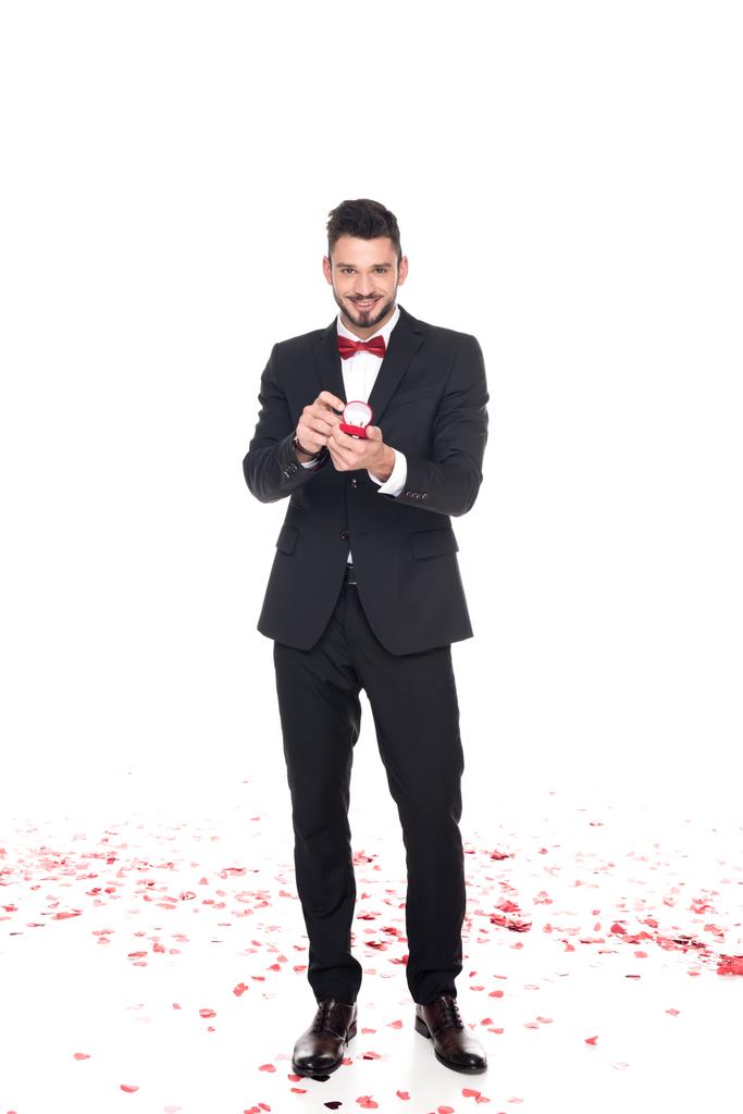homem bonito mostrando caixa vermelha com anéis de casamento isolado em branco, dia dos namorados conceito
 - Foto, Imagem