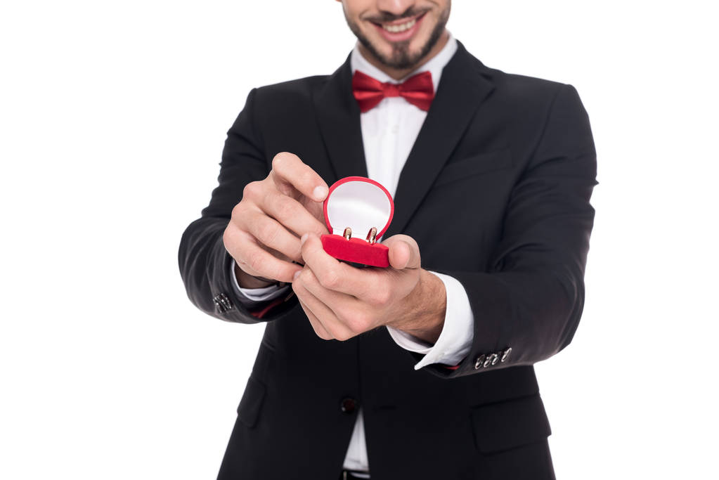 image recadrée de bel homme montrant boîte rouge avec des anneaux de mariage isolés sur blanc
 - Photo, image
