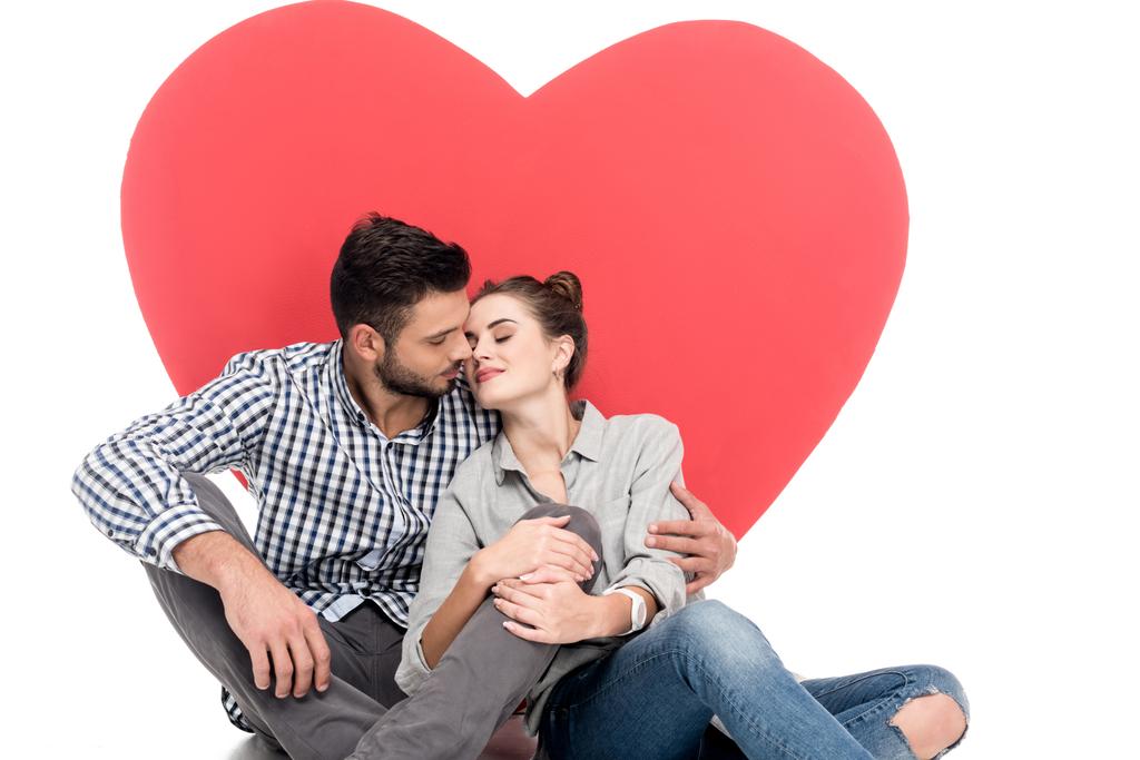 Paar küsst sich am Valentinstag in der Nähe eines großen Herzens - Foto, Bild