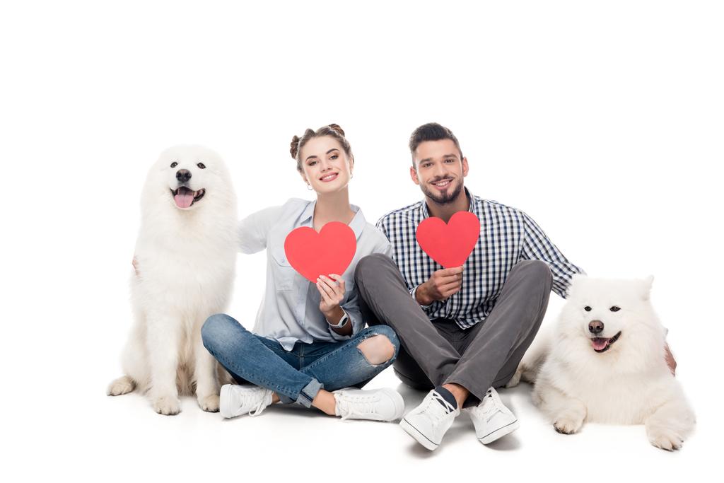 gelukkige paar met Samojeed honden en papier harten op wit, Valentijnsdag concept - Foto, afbeelding
