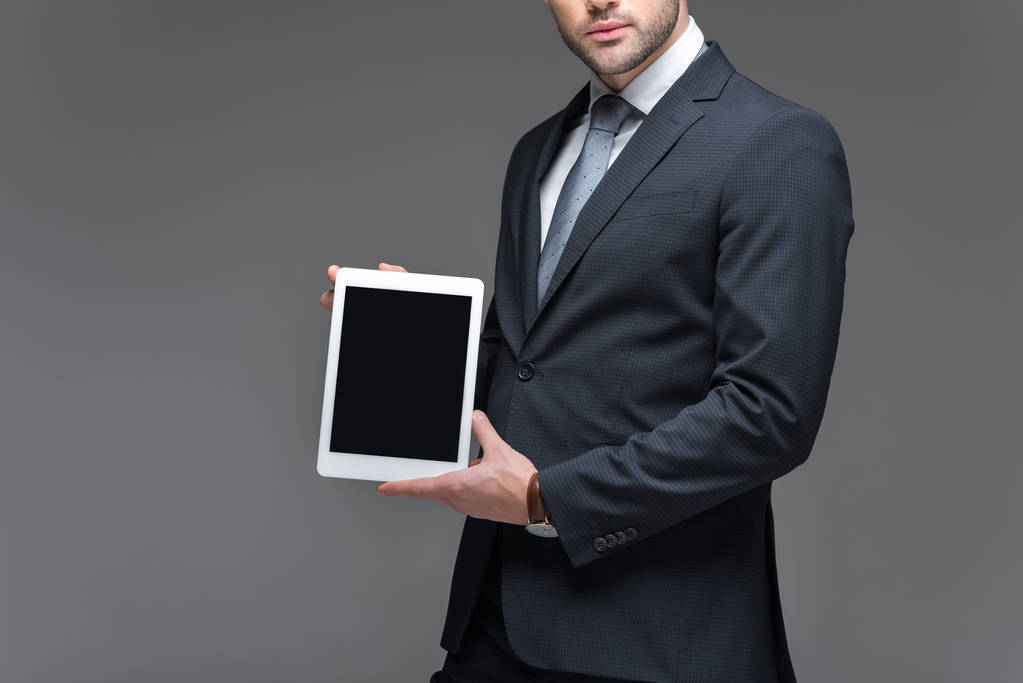 vue recadrée de l'homme d'affaires présentant tablette numérique, isolé sur gris
 - Photo, image
