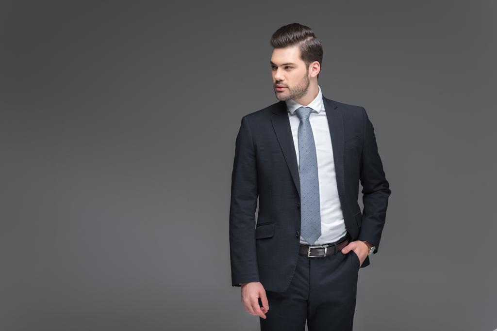 schöner bärtiger Geschäftsmann im schwarzen Anzug, isoliert auf grau - Foto, Bild
